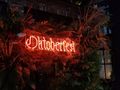 Neon sign surrounded by foliage reads Oktoberfest