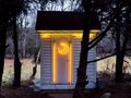 An outhouse with a neon moon symbol on the door